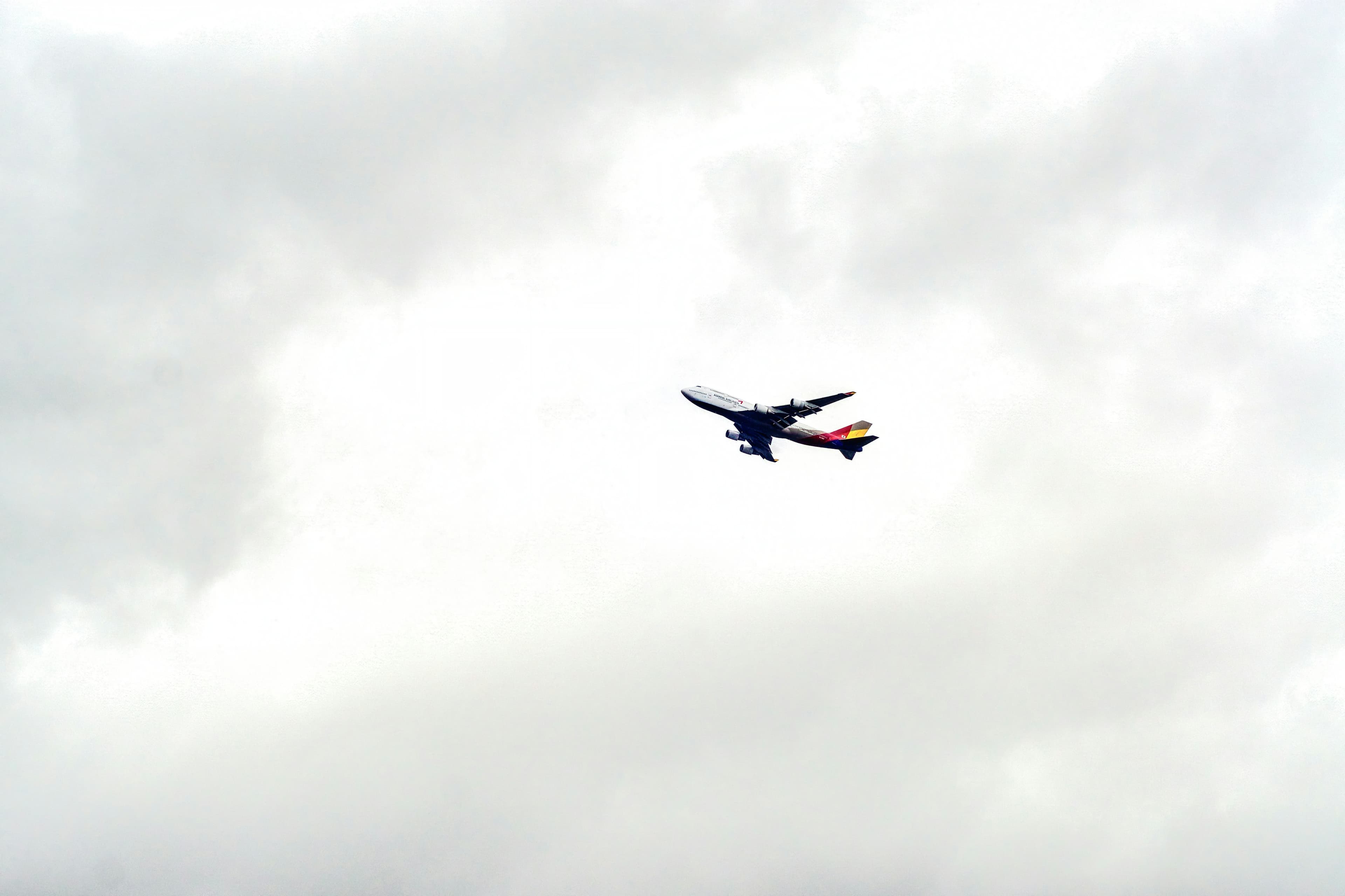 A four-engined airliner climbing into heavy overcast